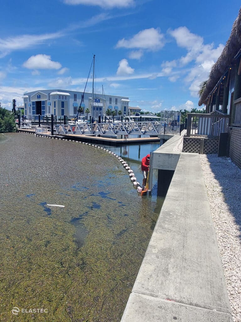 Installing aquatic weed containment barrier around a dock